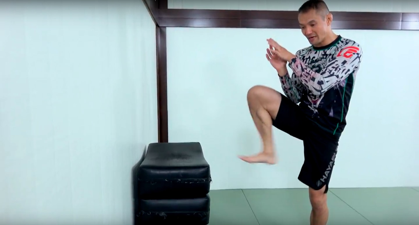 training the foot jab against a wall for kickboxing